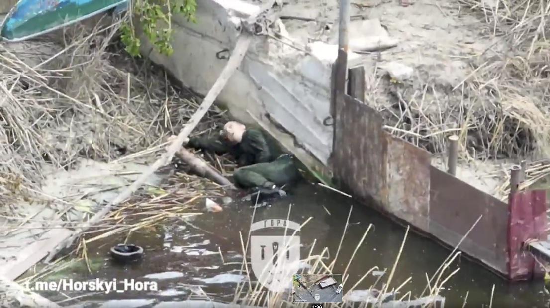Trio of Russian paratroopers in a boat are targeted by drone dropped grenades. One of them eventually blows himself up sending his body into the air spectacularly