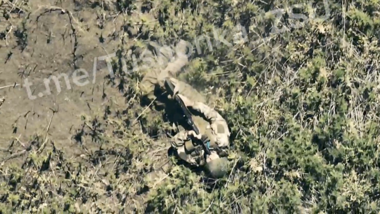 Russian crawling across the field is attacked by drone droppings. Decides to shoot himself instead