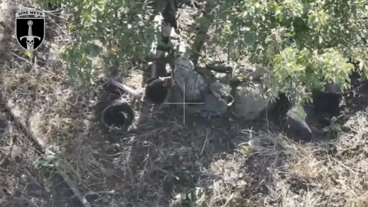 Russian soldier lying under the tree with his helmet off shoots himself