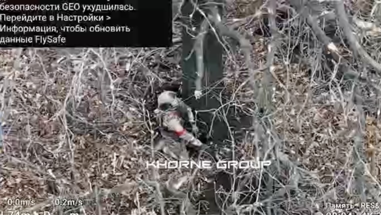 Fully equipped Russian with no visible injury appears to shoot himself under tree to no immediate success. Minute or two later he seems to eventually collapse
