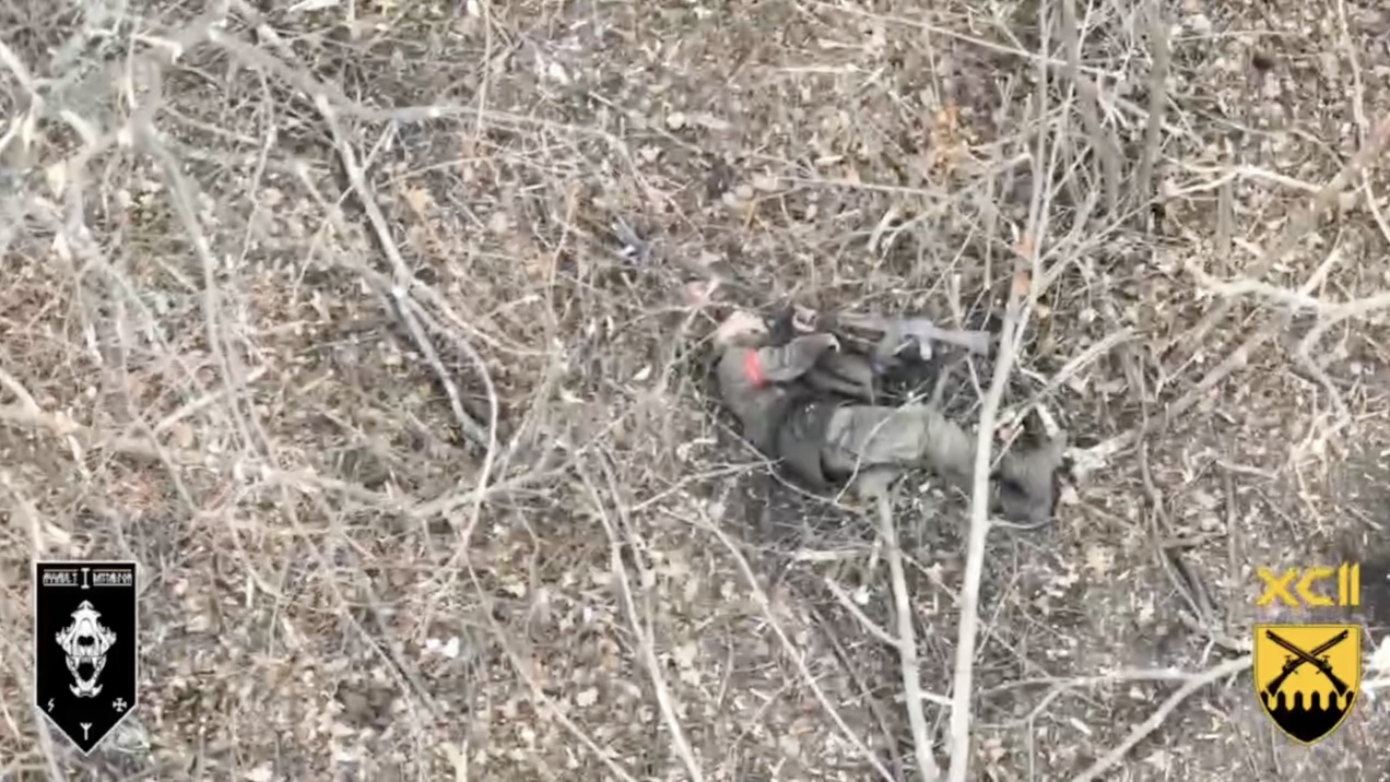 Russian soldier is seen lying on the ground in what looks like typical post-suicide position with his AK pointing at his mouth