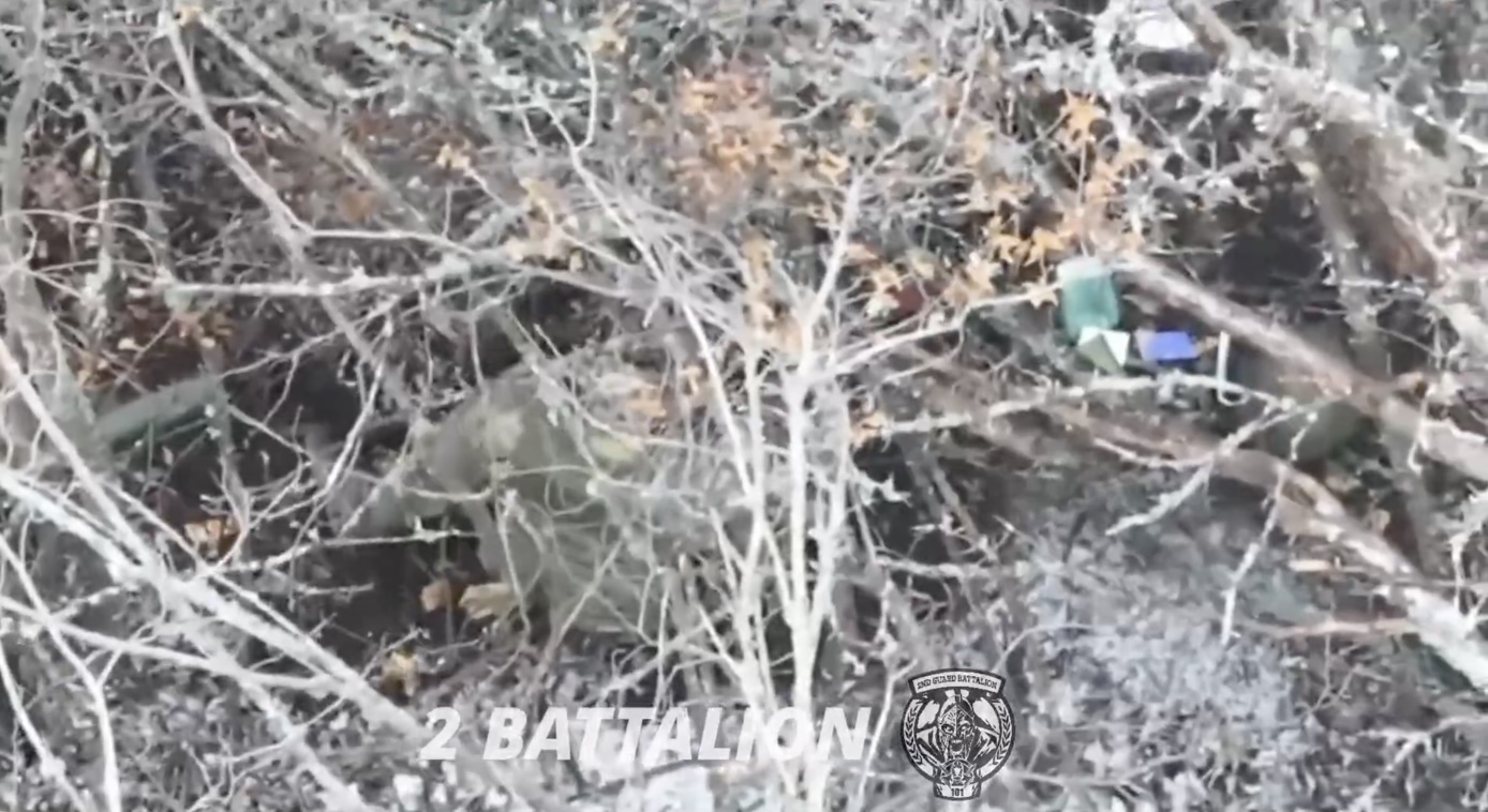 Russian is seen sitting under the tree, grabs his AK and shoots himself