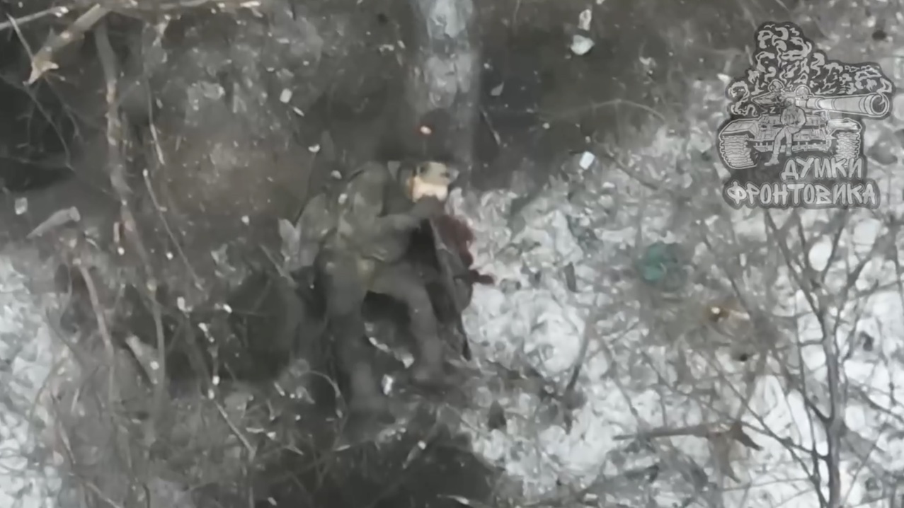 Russian soldier is seen apparently dead with AK pointing at his head and his hands resting on it