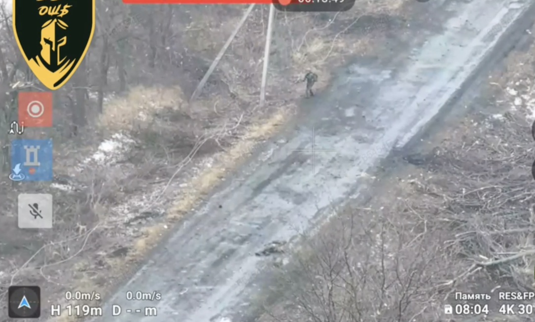 Two Russians walk along the road. One is hit with something that takes him down, he swiftly proceeds with shooting himself while his comrade retreats