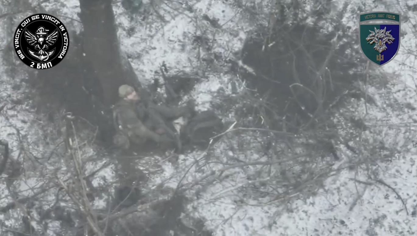 Russian is sitting under the tree with AK to his head. FPV drone suddenly arrives, he barely dodges, then moves around, points AK at his head again and shoots