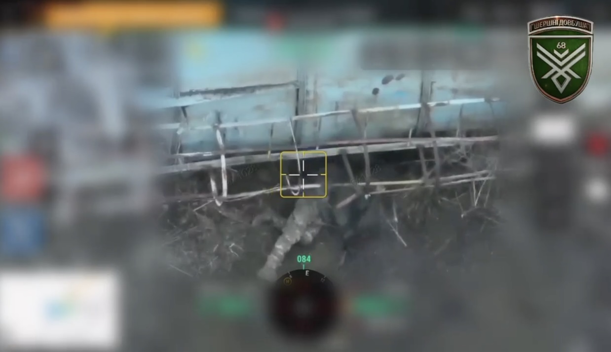 Russian is hiding under some sort of tanker. After close drone drop he's seen grabbing his rifle and shooting himself