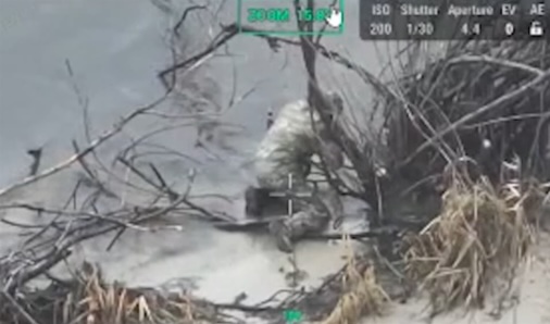 Russian soldier is standing kneeled in the water, shoots himself