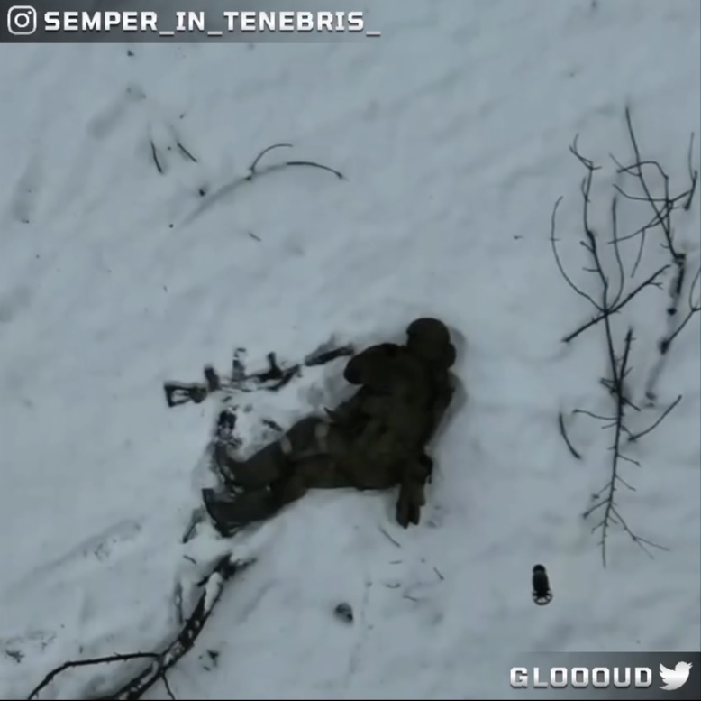 Russian receives drone drop nearby while walking on the snow. He falls down and proceeds with detonating grenade next to his neck moment before another drop arrives closer