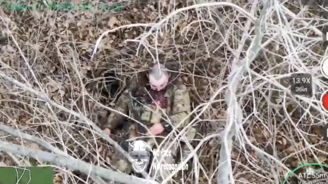 Russian soldier walks along treeline towards destroyed SUV, is attacked by drone dropped grenade, later is seen shooting himself among trees, his helmet blown away