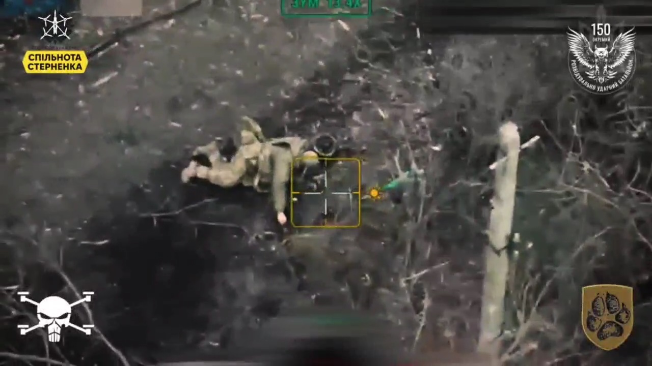 Wounded Russian lies on his stomach on dirt road. With FPV drone coming to finish him off, he props up and shoos himself in the side of the head