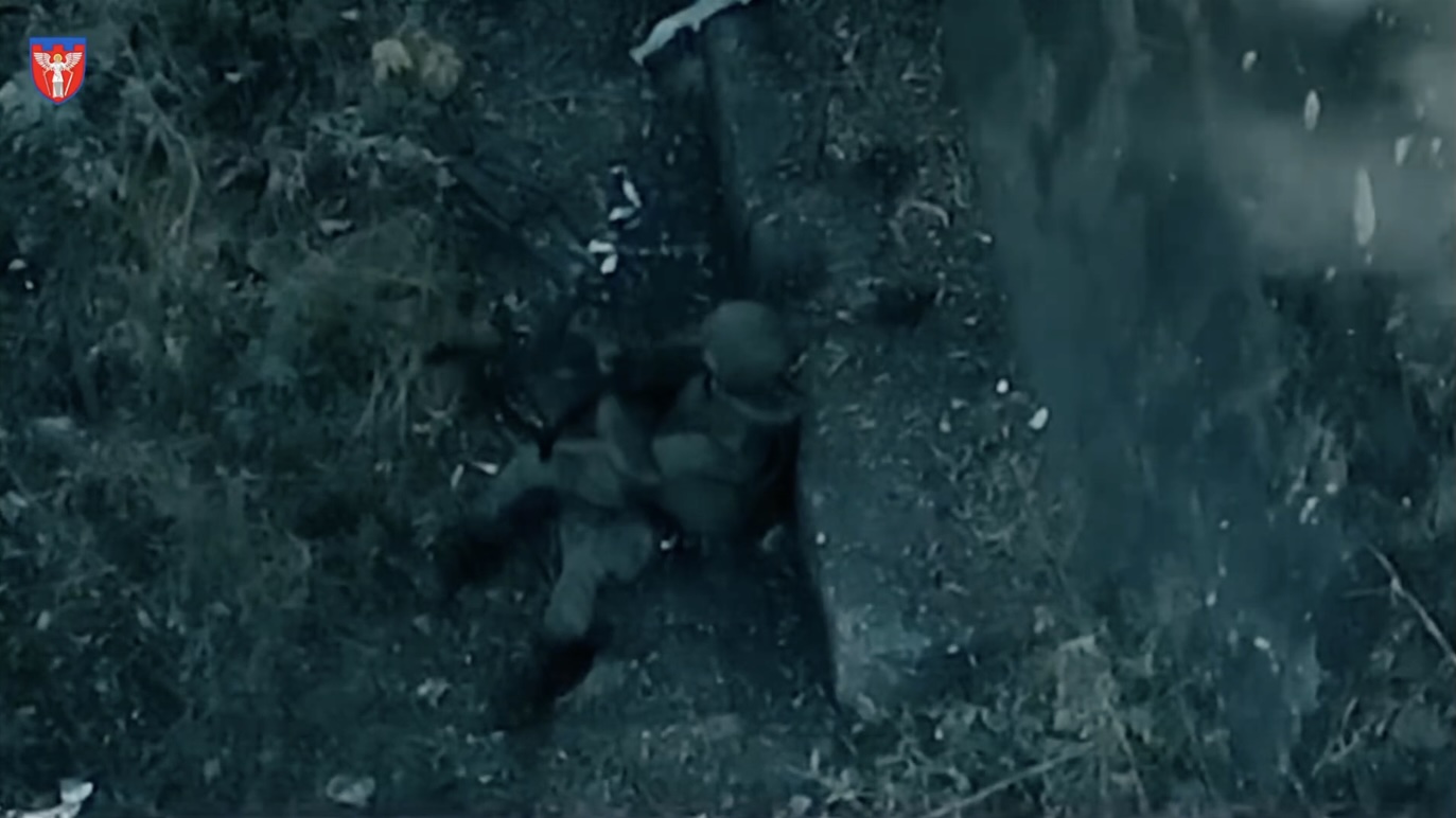 Russian is hiding under railway bridge, either wounded or exhausted. He first tries to shoot himself with AK to his chin only to hurt himself, then tries again holding it in front of his face, this time successfully