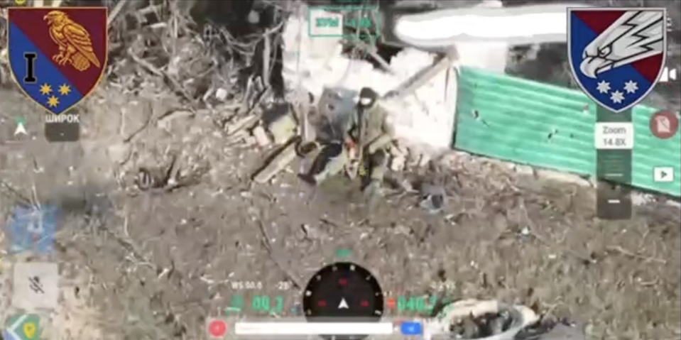 Russian is seen sitting under ruin at the end of nearly intact long green fence holding his rifle under his chin and pulling the trigger