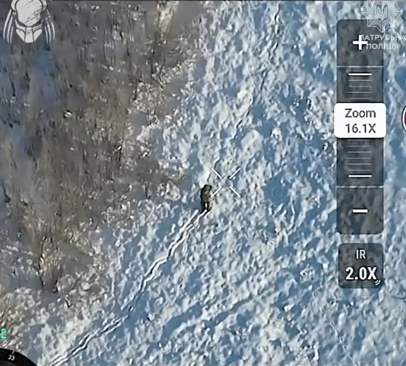 Russian walks on thick snow besides trees, something hits the ground nearby. He continues 20 more meters, then shoots himself