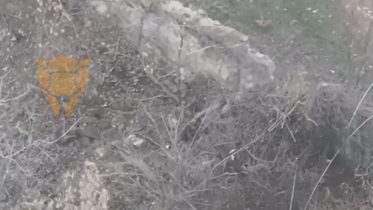 Russian with no helmet sits under half ruined wall, fumbles with his rifle for a while, then finally shoots himself