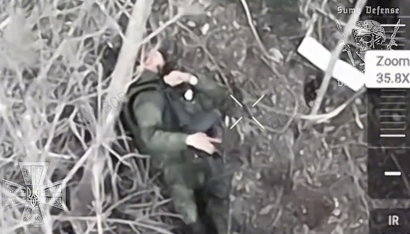 Russian puts AK under his chin and shoots after a bit of aiming, bullet entry is visible but somehow he's still alive and doesn't even seem critically disabled. He slowly puts AK aside, and rolls around the place in agony touching his head