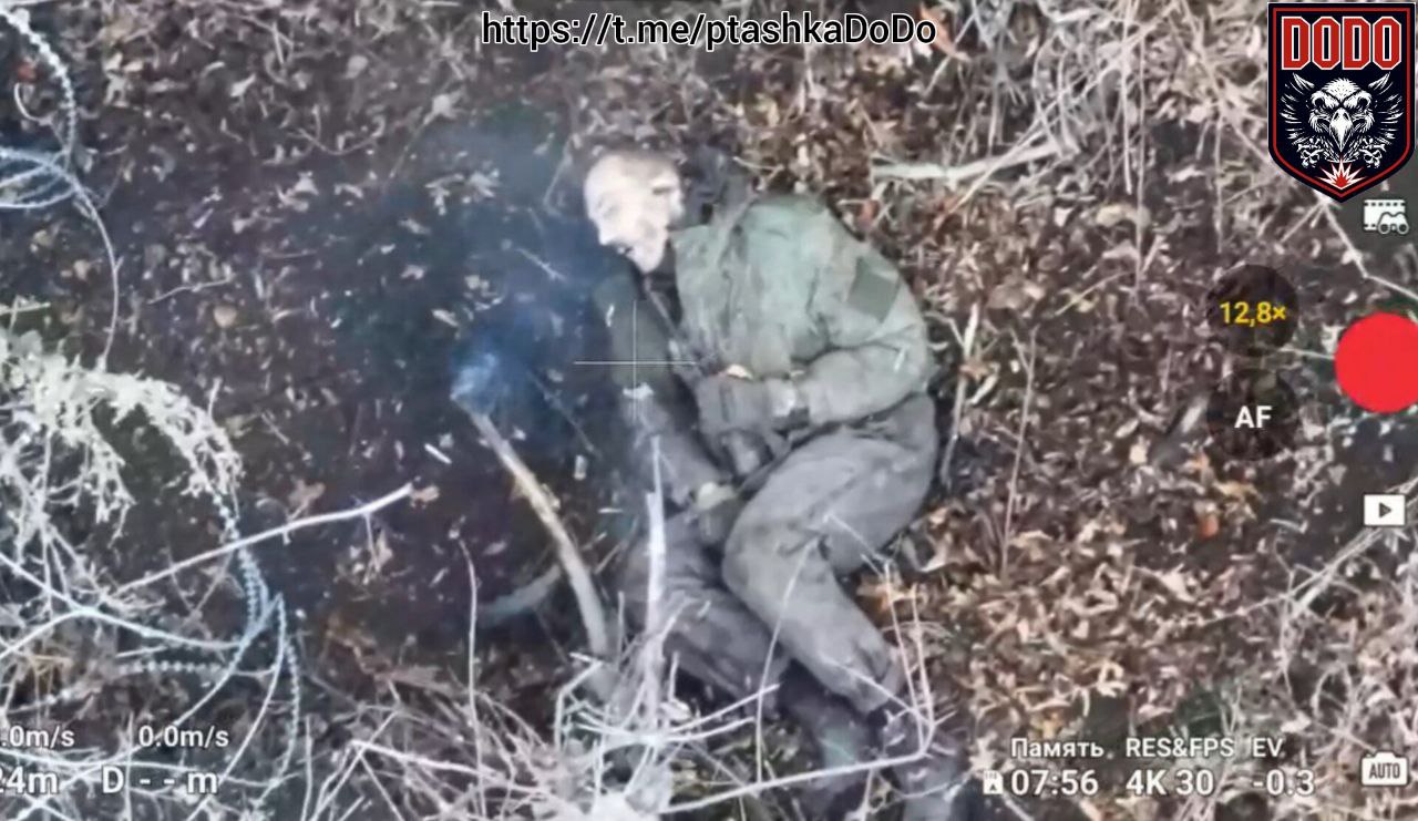 Photo of dead Russian soldier in typical post suicide position, he's still holding his AK