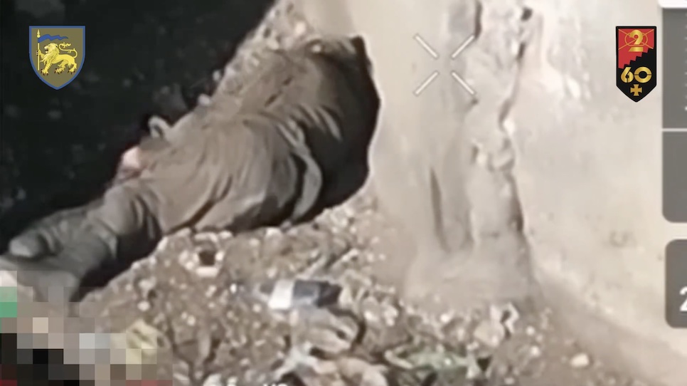 Russian with no visible injury sits under some kind of wall in the bright sun, the video is sped up. He fumbles with his rifle, takes what looks like a cigarette, drinks some water, then turns to his side away from camera and appears to shoot himself, not without some hesitation