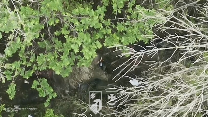 Russian soldier is seen right from above through tree branches testing his AK and shooting himself immediately