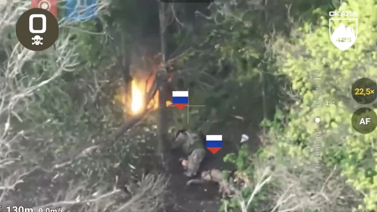 Russian soldier lies under the tree besides his apparently dead comrade and some open fire, rolls over grenade and detonates it
