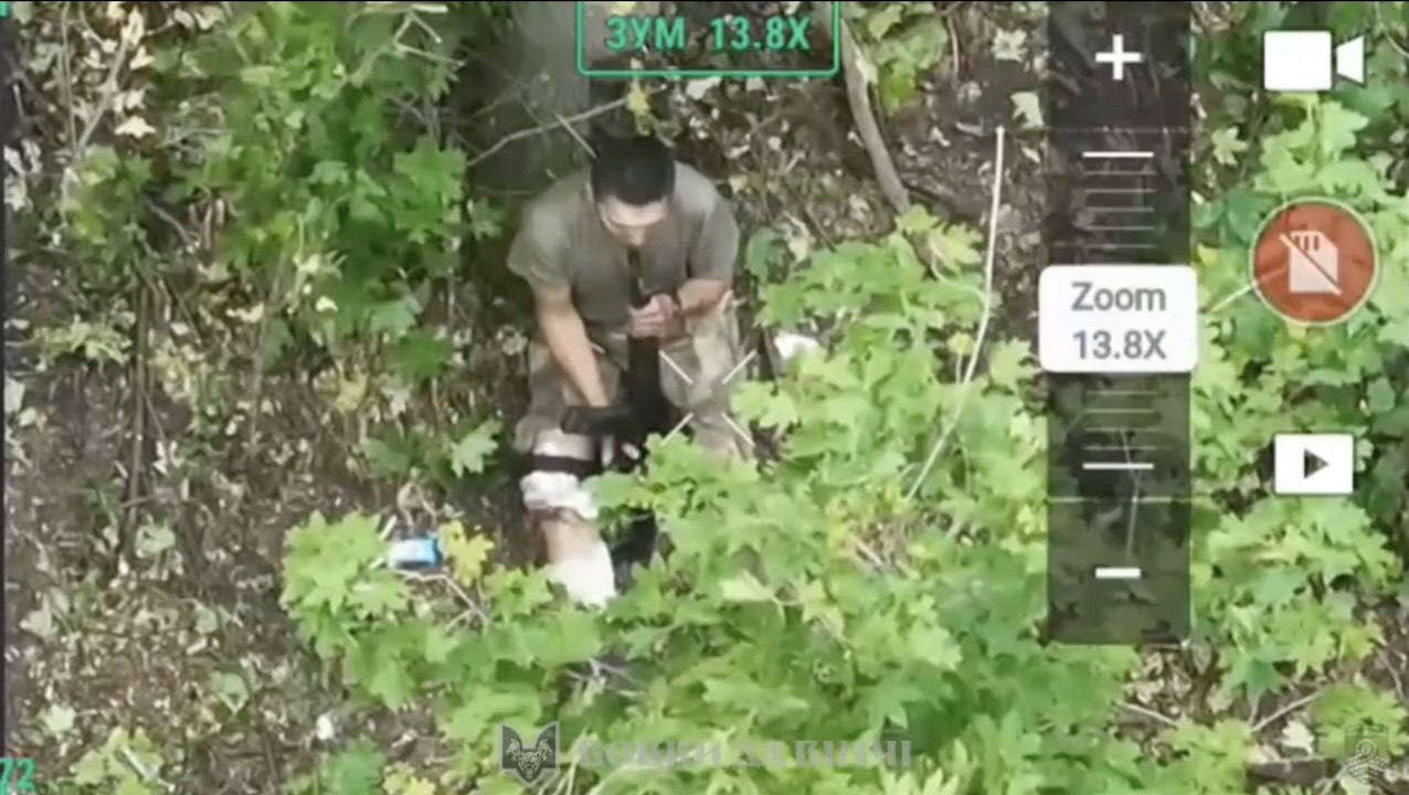 Russian with no helmet and armor is sitting under the tree and shooting himself with his AK right under his chin