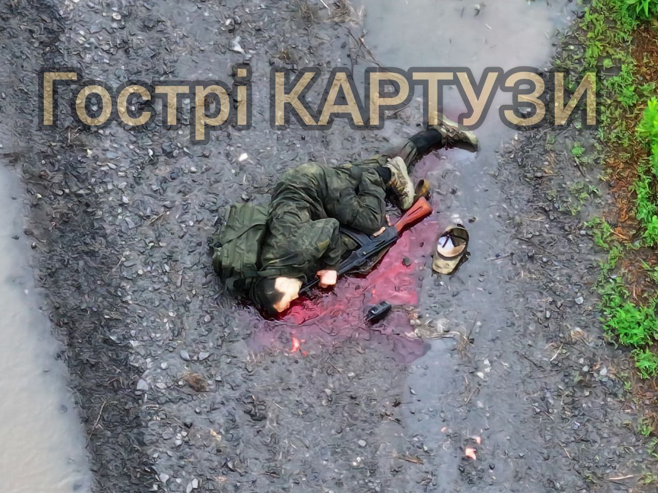 Russian soldier walking alone in the rain is struck on a road by a drone drop. He falls on the ground and shoots himself in the head seconds later. Hi-res camera zoom-in reveals him lying in the puddle of blood