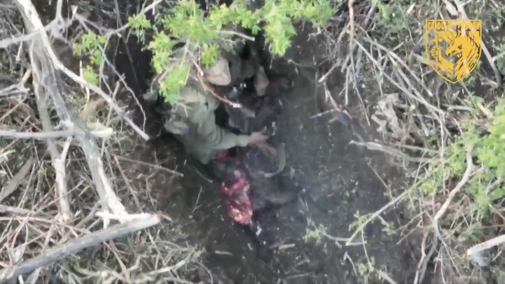 Russian is lying under foliage with freshly wounded legs and no helmet, one of his feet is blown off. He throws it out of the way, grabs AK and shoots himself swiftly