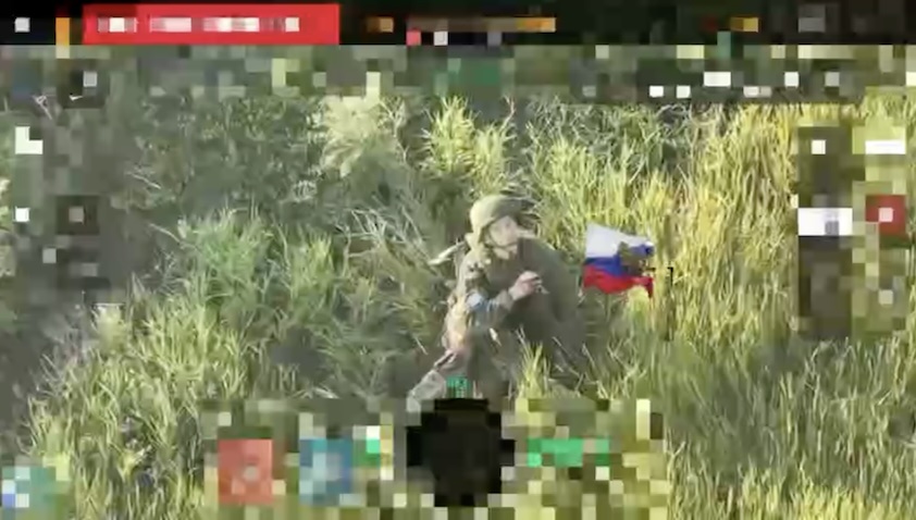 Quick cut of Russian soldier sitting in the grass with no visible injury, pointing his AK under his chin and shooting himself