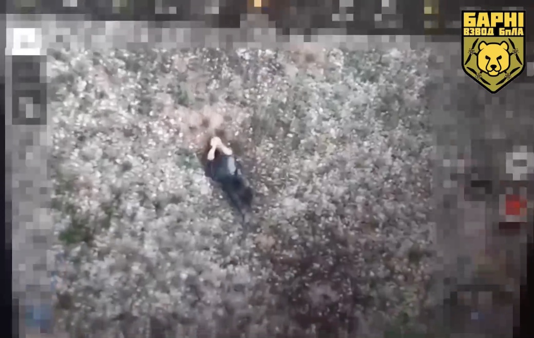 Russian is seen lying on his back in the open area, he blesses himself with a cross, puts grenade under his vest and detonates it