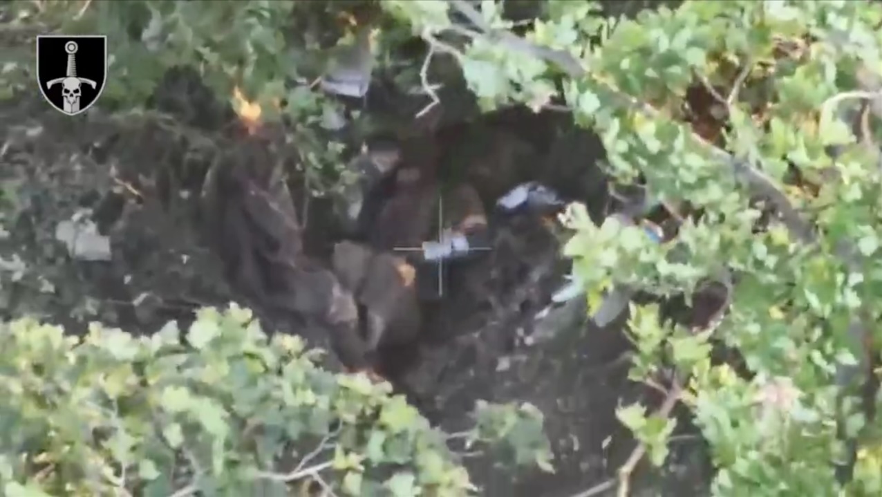 Fully equipped Russian soldier is hiding under dense foliage, takes out grenade and leaves it on his chest for a while, apparently hesitant. Then puts it near his belly and cramps, nothing happens for a few moments, then it explodes as he reaches out with his hand to check on it