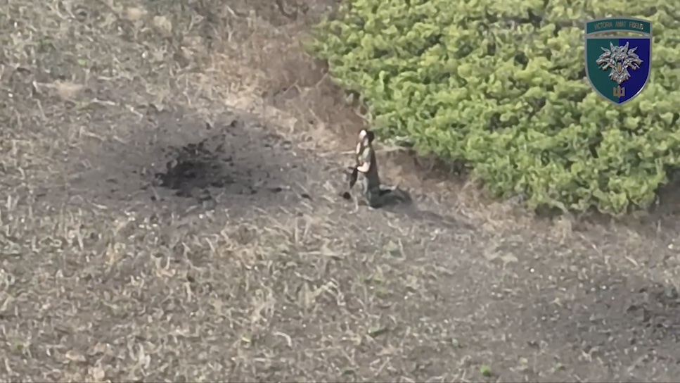 Unequipped Russian stands kneeled besides bushes, takes AK with silencer, makes test shot, points it under his chin and pulls the trigger. Somehow he misses, makes another attempt right away but still alive. Is seen rolling on the ground with blood all over his face for several more minutes