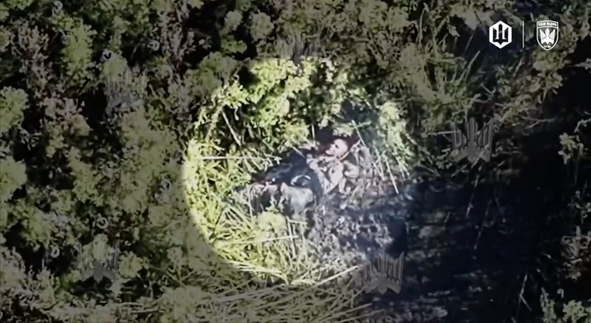 FPV hunts down fully equipped Russian soldier moving in dense bushes, hits close. Another drone zooms in as he's down on the ground, grabs his AK, points under his chin, makes what looks like test shot, then shoots himself