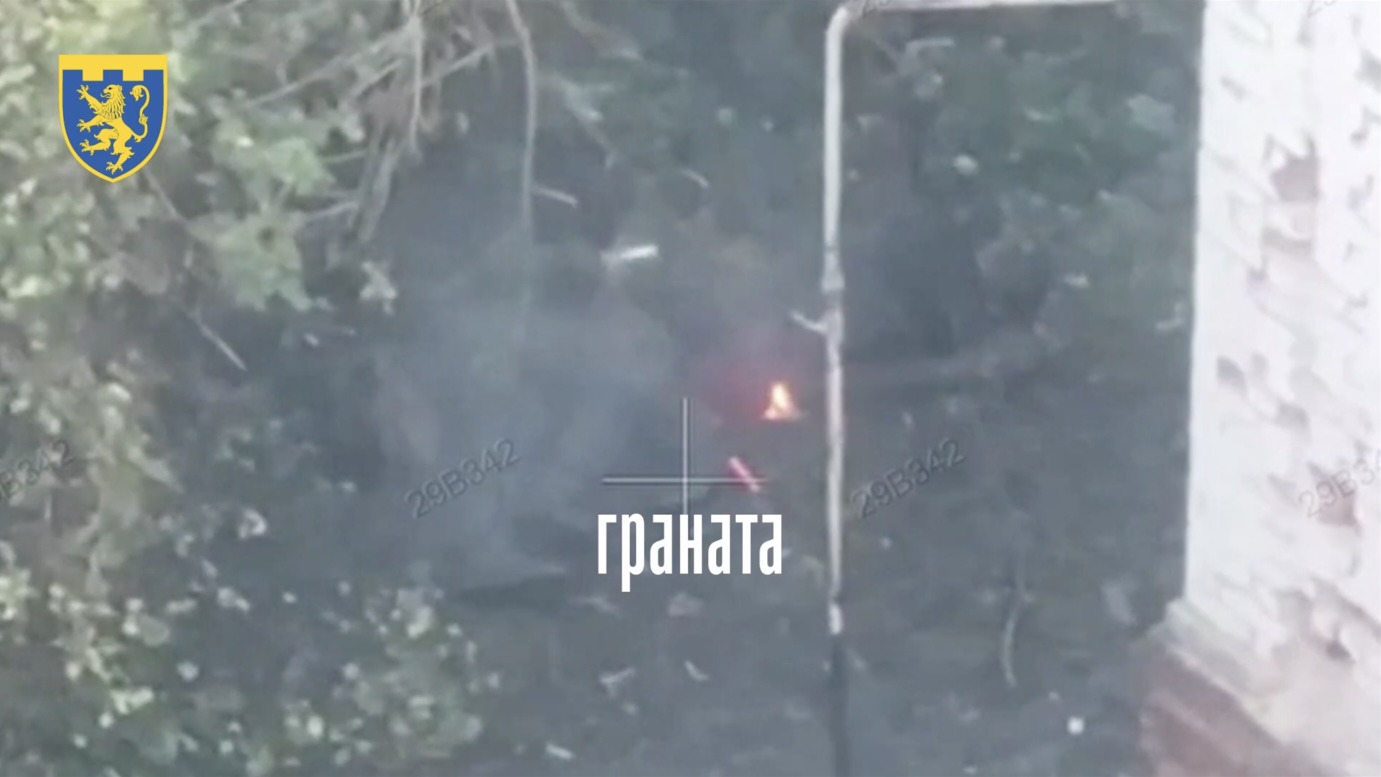 Two Russians walk along the street, receive close hit, one is injured. They hide in the trees besides the road, receive another hit. One of them is seen pulling the pin on his grenade and detonating it soon after the strike