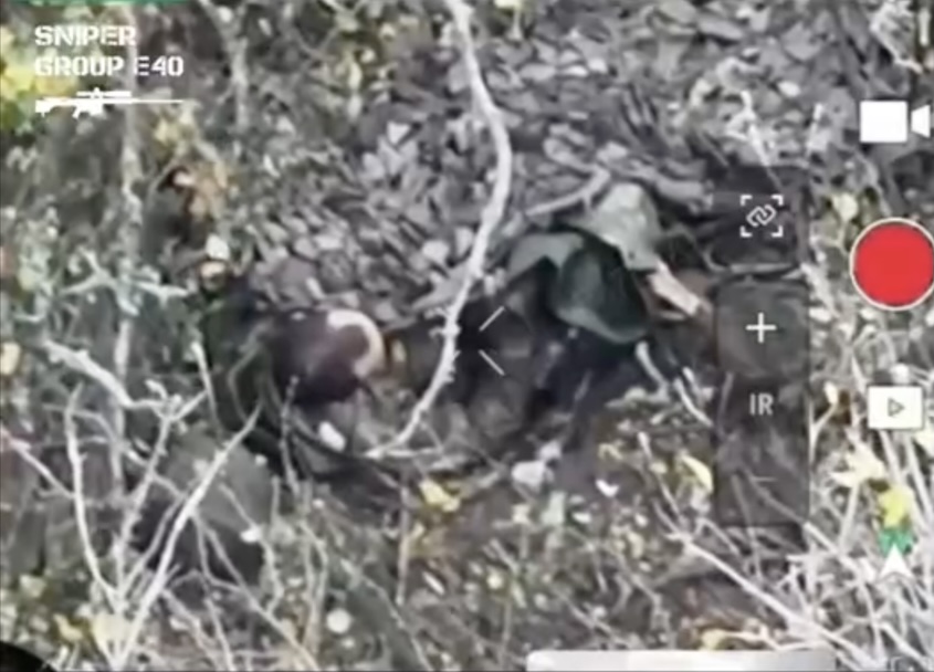 Short clip featuring Russian with no helmet shooting himself while lying on his back and covered with camouflage