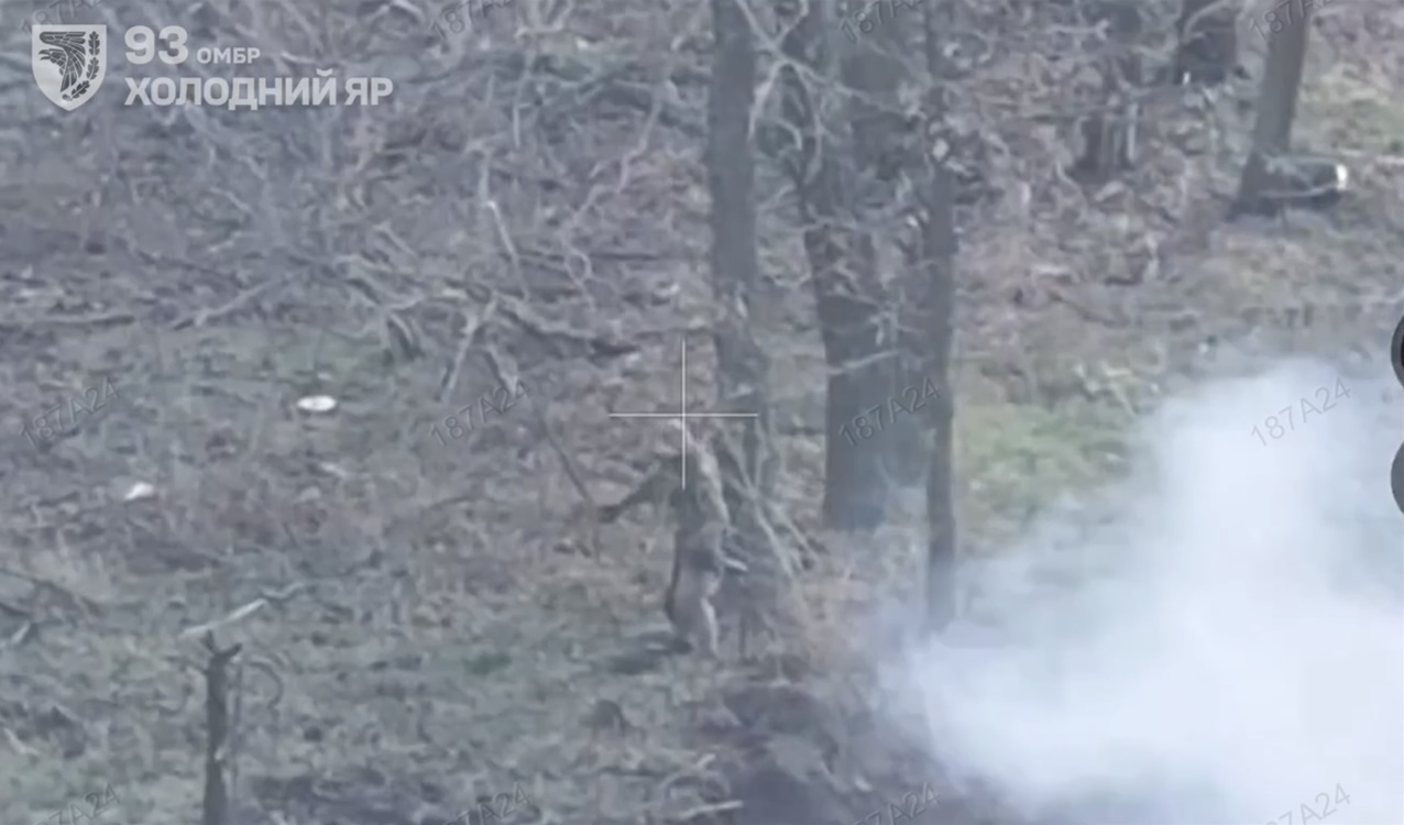 Russian stands up in what looks like aftermath of explosive attack. He holds AK down in his hand but instead proceeds with dropping grenade in front of himself and lying on top of it, followed by explosion