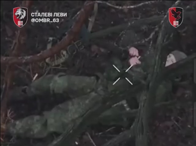 Russian with bandana is lying under the tree, which obscures the view. He pulls the pin on his grenade and leaves it to detonate on his belly while holding his hands to his ears. Explosion doesn't seem to kill him immediately