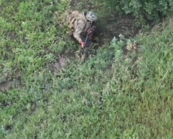 Fully equipped Russian is hiding under the bush in the open field, receives drone drop, grabs his AK and shoots himself in the temple while the rifle keeps firing on full auto