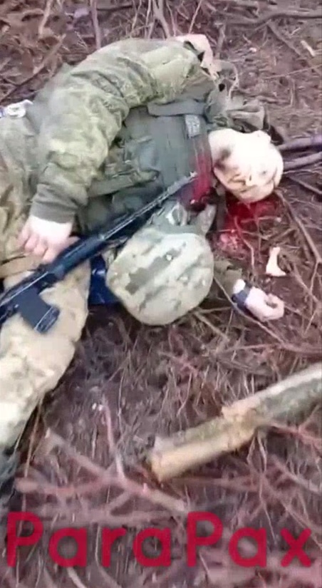 Closeup footage of apparently an aftermath of Russian soldier having killed himself. He's lying on the ground with AK in his hand and bullet hole under his chin. There's puddle of what looks like fresh blood under his head.