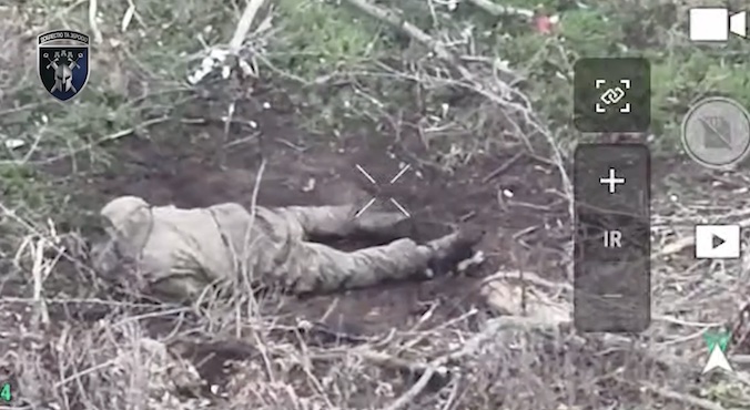 Russian is sitting on the ground with no helmet, pulls the pin on his grenade, and lies face down on it, followed by explosion that visibly throws his body up in the air