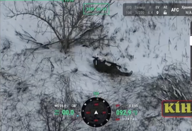 Russian lies on the snow besides the tree firing at something with his AK, then turns around and shoots himself