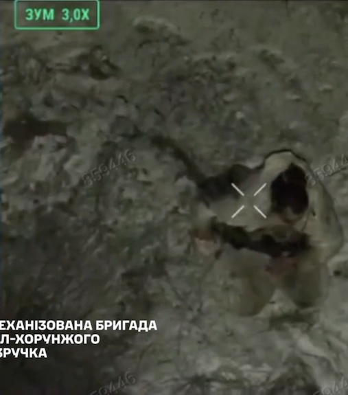 Russian soldier is seen standing on his knees, he briefly looks at the drone that's watching, pulls the pin on his grenade and leaves it detonate besides him