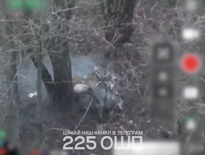Russian with no helmet sits on the ground leaned against the tree. Since he can only move one hand, he pulls the pin on his grenade while holding it between his legs, then leaves it detonate on his belly