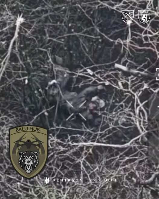Apparently injured Russian lies on the ground, is seen through tree branches. He pulls the pin on his grenade, rolls over it, and detonates under his chest