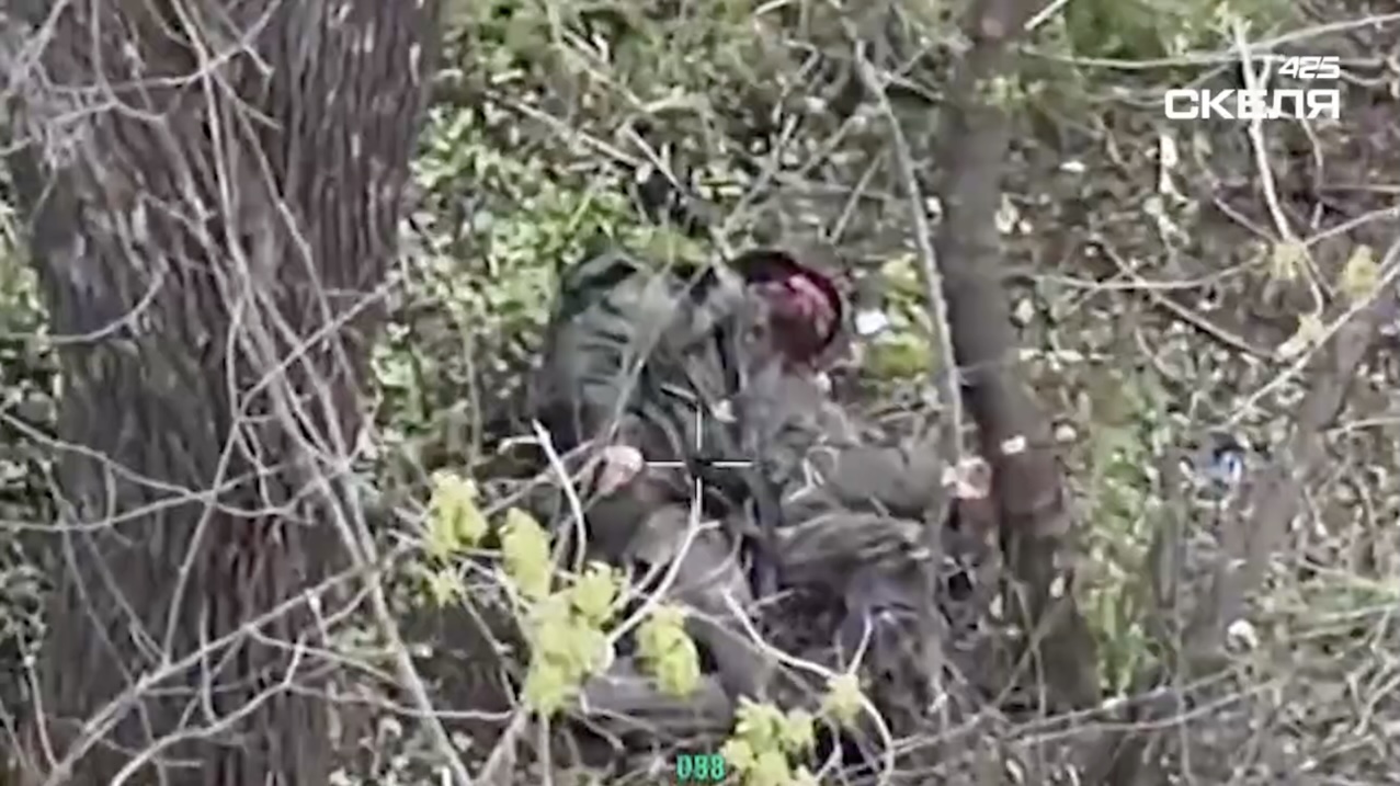 Russian is seen walking in a tree line, stops by a tree. While standing there, he receives an attack of unknown nature. Soon after he appears to shoot himself