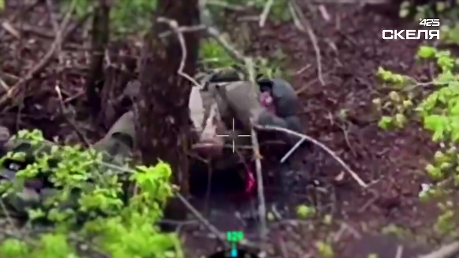 Same video, different Russian. He appears to get under unknown attack while walking in extremely green tree line. Later is seen on the ground, fully eauipped, leaving his grenade detonate besides him