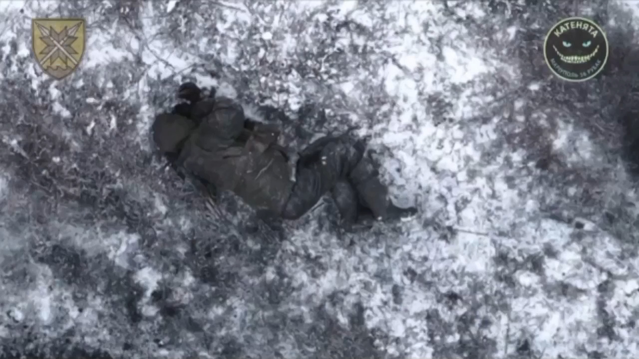 Russian soldier laying on his side hit with drone drop grenade then kills himself with his own