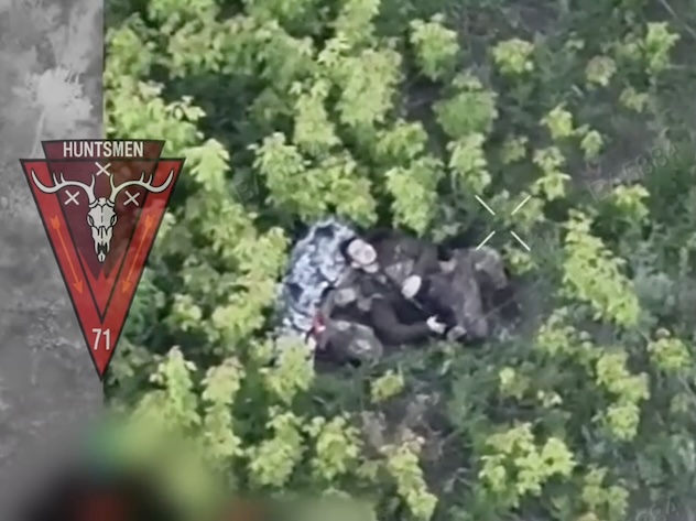 Russian soldier with no helmet is seen lying on his back besides his backpack and shooting himself from AK