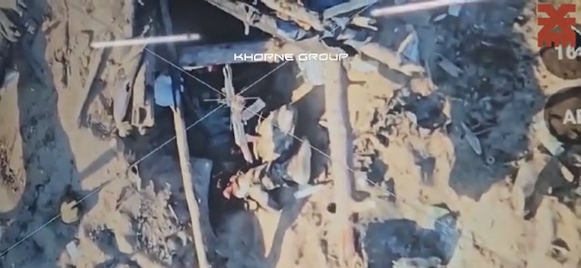 Russian soldier with horrible wounds fumbles with his rifle, possibly trying to aim it at his head