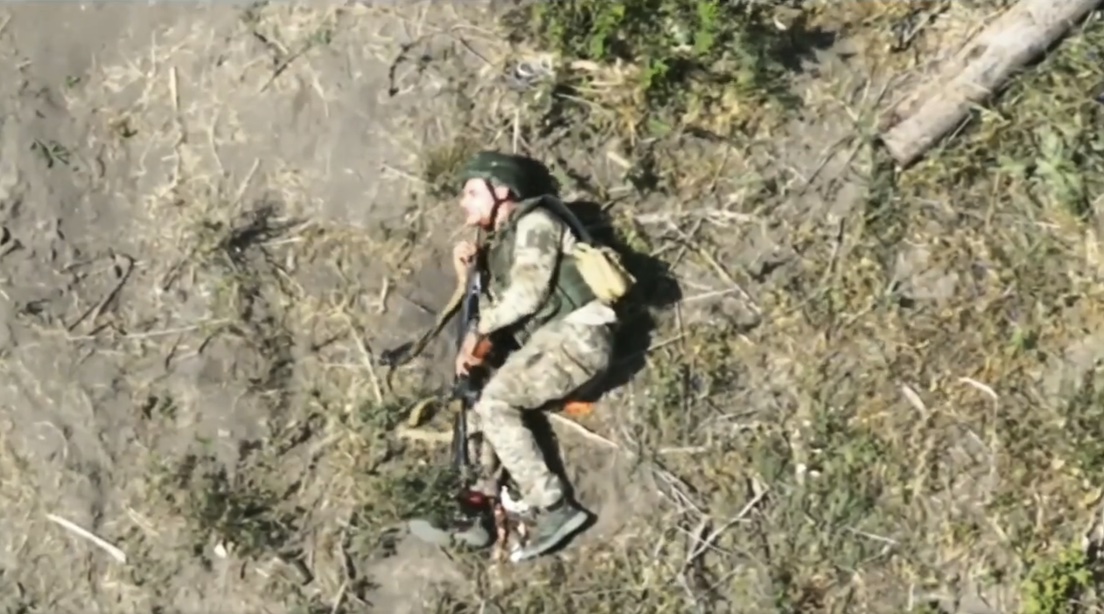 Fully equipped Russian soldier with no visible injury says something in his radio, then shoots himself lying on the ground